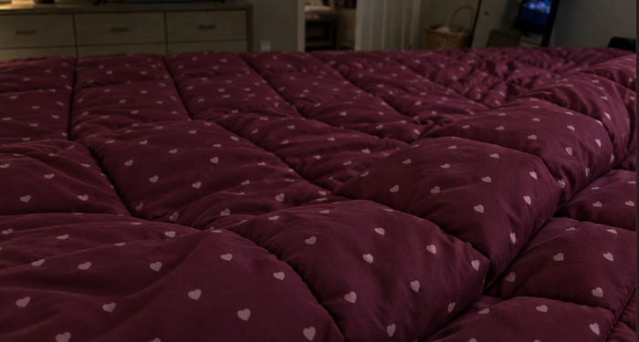 AI-generated demo image of the HelloBed Burgundy Hearts comforter in a home setting.