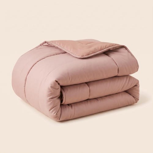 Blush comforter folded on an ivory background